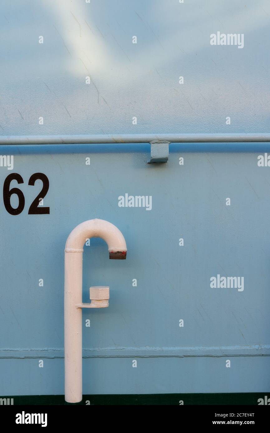 Vertikale Aufnahme einer hellblauen Oberfläche mit einer gekrümmten Pipe und eine gedruckte Nummer 62 Stockfoto