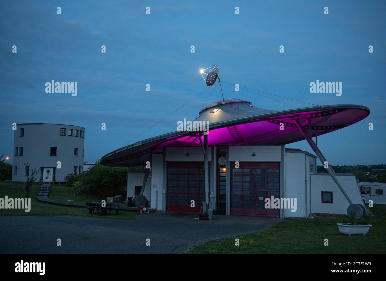 07. Juli 2020, Rheinland-Pfalz, Fließem: Wolfgang Daldroppens Kraftfahrzeug-Testzentrum sieht aus wie ein UFO (unbekanntes Flugobjekt). Die ursprüngliche Konstruktion mit einer Satellitenschüssel an der Spitze steht auf sechs Füßen mit zwölf Rädern und wiegt rund 20 Tonnen. Nachts wird das Dach in verschiedenen Farben beleuchtet. (Zu dpa 'EIN UFO in der Eifel: Unter dem Dach wird getestet') Foto: Harald Tittel/dpa Stockfoto