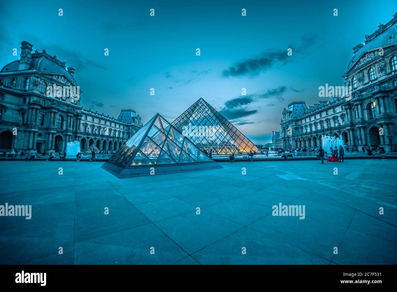 Glaspyramide des Louvre unter dem nebligen Blau und Rosa Himmel vervollständigt die Szenerie des Pariser Abends Stockfoto