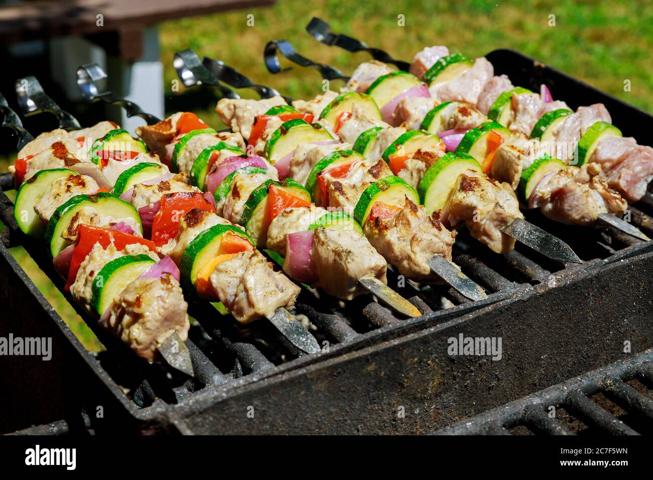 BBQ Spieße mit Schweinshash Kebab und Gemüse auf flammendem Grill. Stockfoto