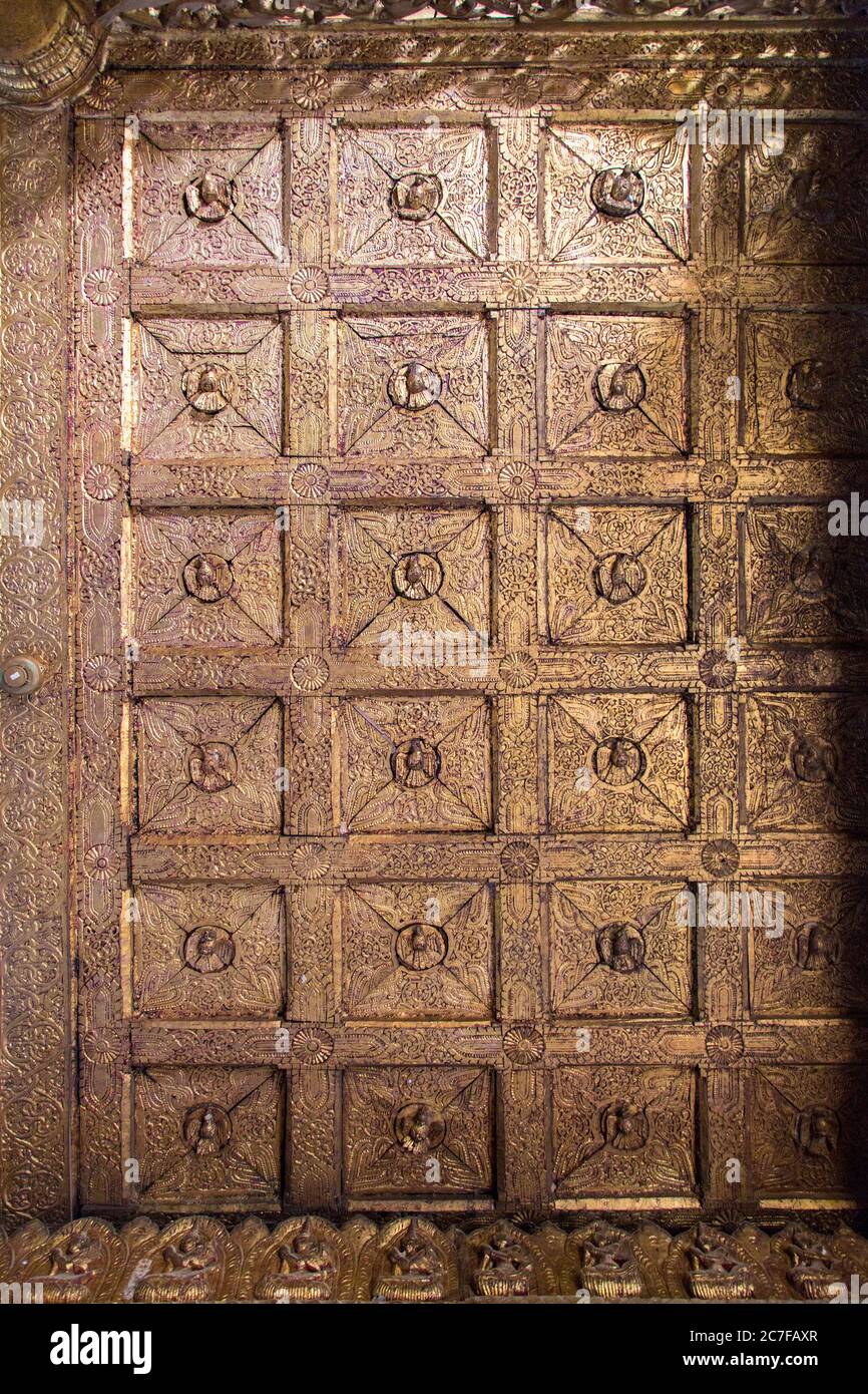 Detail einer Türscheibe mit verschlungenen Holzschnitzereien in einem Tempel in Yangon, Myanmar Stockfoto