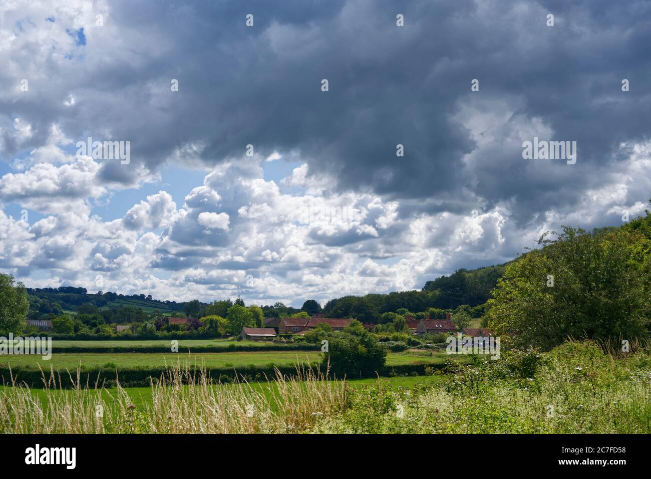 Blick auf das Dorf Dulcote und Ackerland an einem bewölkten Tag. Stockfoto