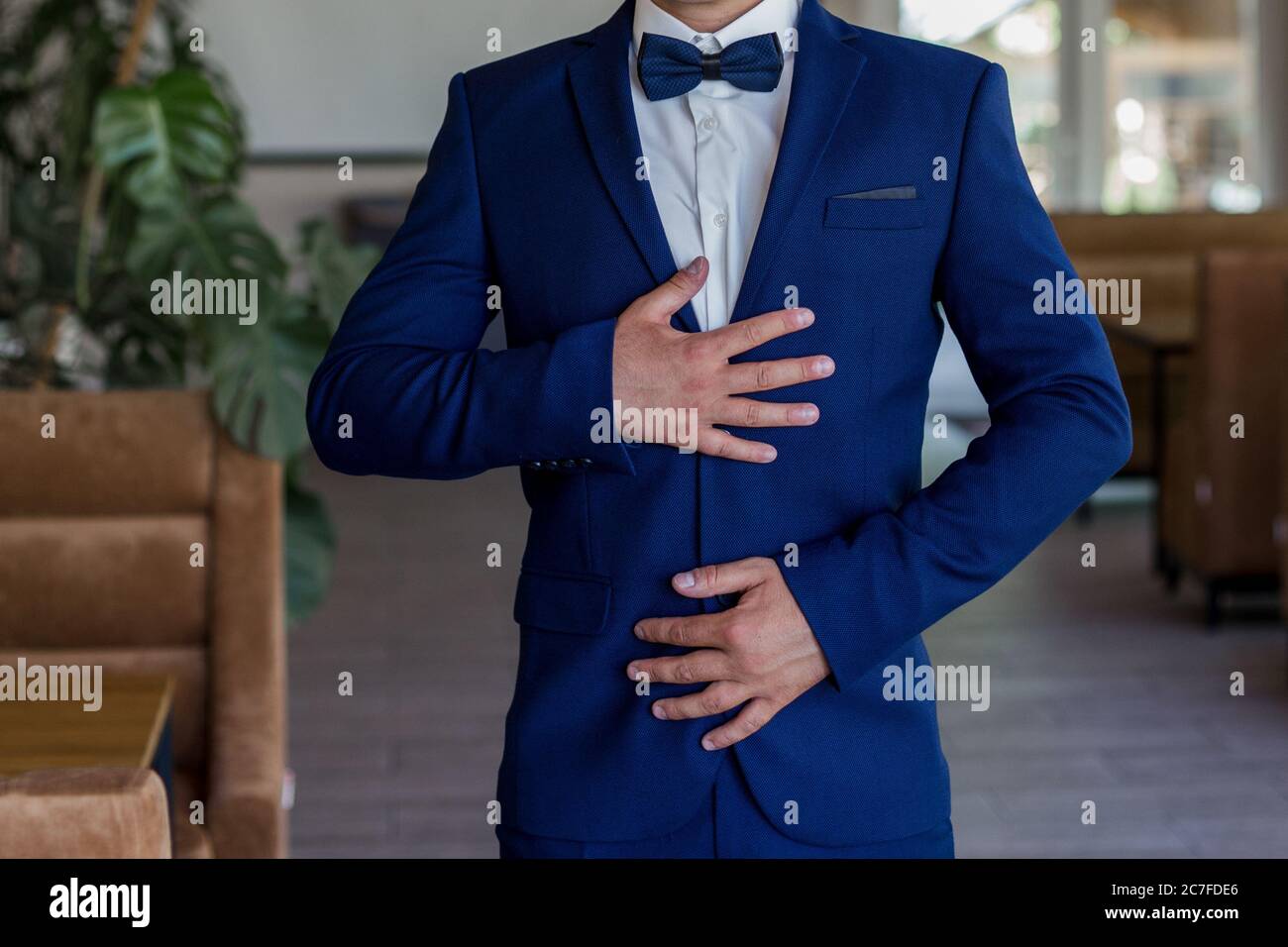 Ein Mann in blauem Anzug und Fliege Stockfotografie - Alamy