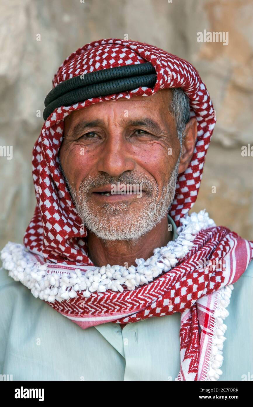 Ein Porträt eines Beduinen-Mannes in Jordanien, der ein Keffiyeh auf dem  Kopf trägt. Die Kopfbedeckung ist rot-weiß kariert Stockfotografie - Alamy
