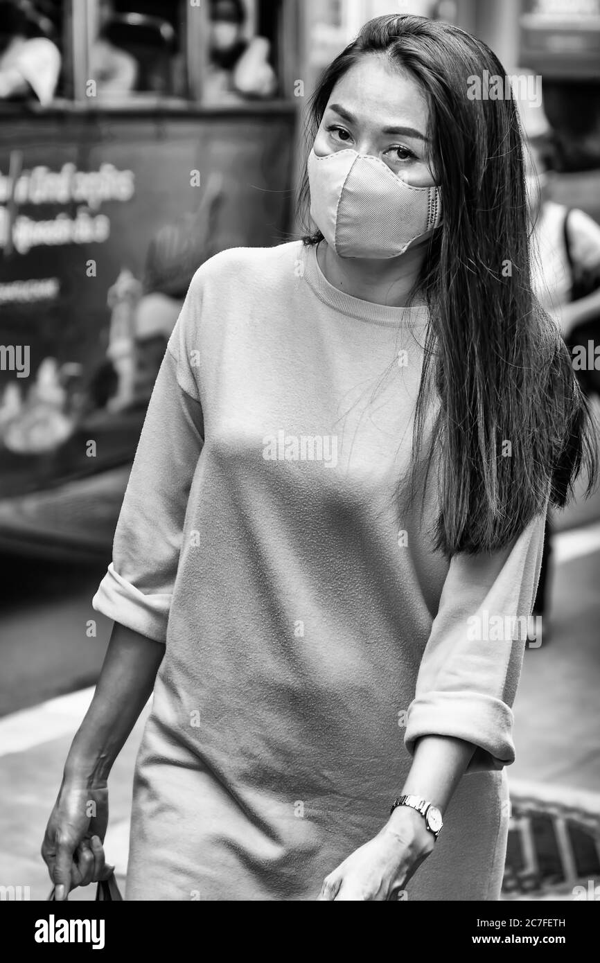 Attraktive Dame trägt Gesichtsmaske in der Straße während covid 19 Pandemie, Bangkok, Thailand Stockfoto