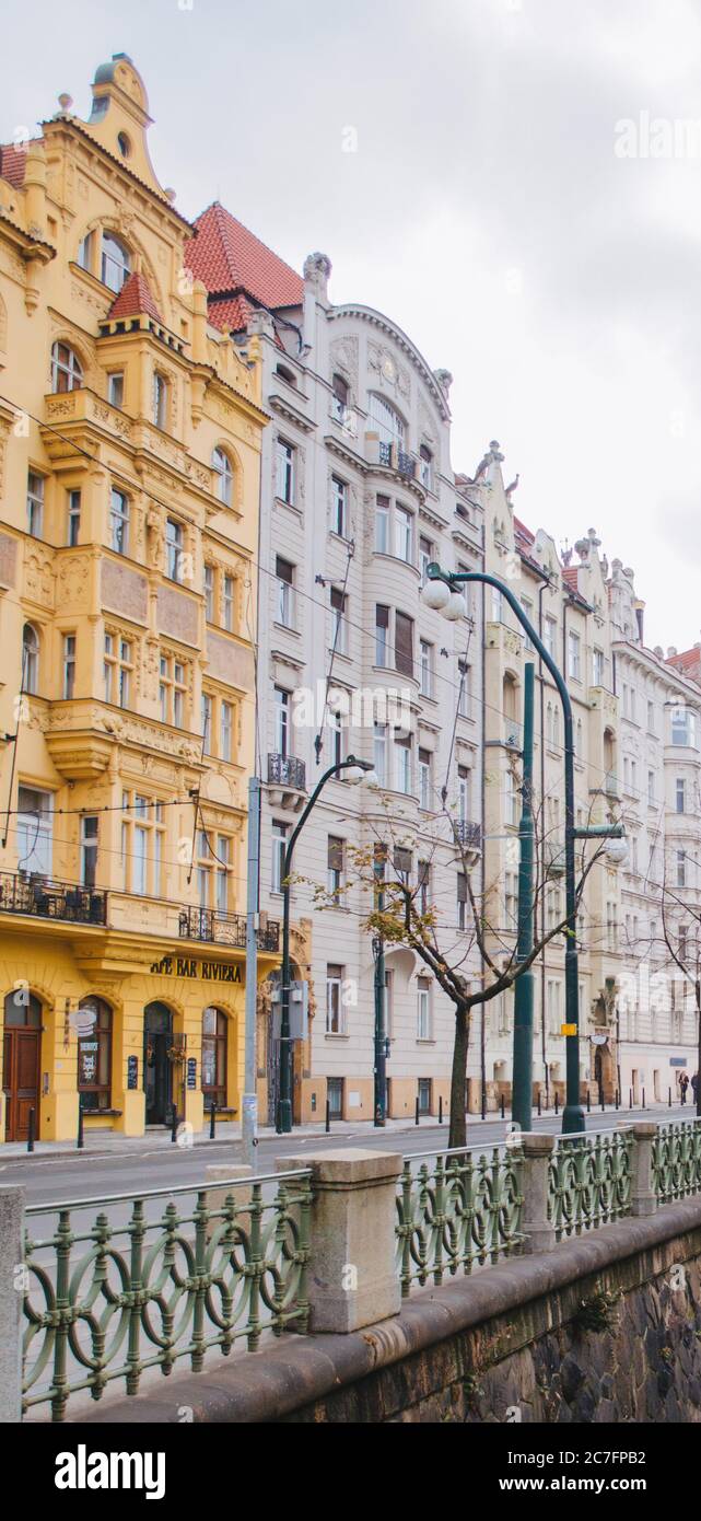 Bunte pastellfarbene Häuser voller Fenster, die an einem bewölkten Nachmittag in Prag, Tschechien, auf die Straßen gerichtet sind Stockfoto