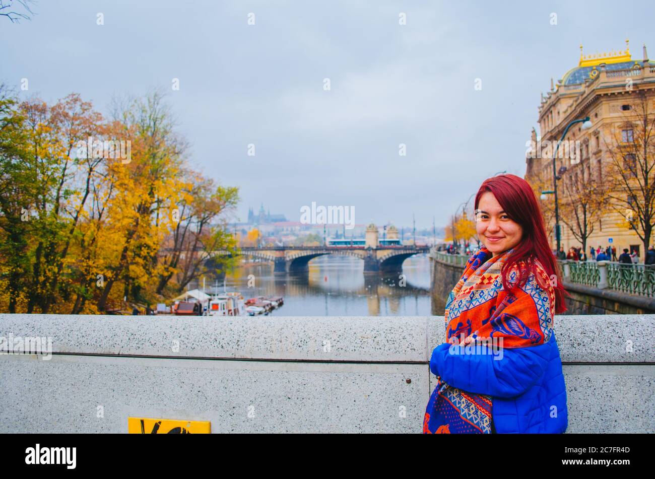 Eine rothaarige brasilianerin in ihren 20ern vor einer Brücke in Prag, Tschechien und lächelnd zur Kamera. Stockfoto