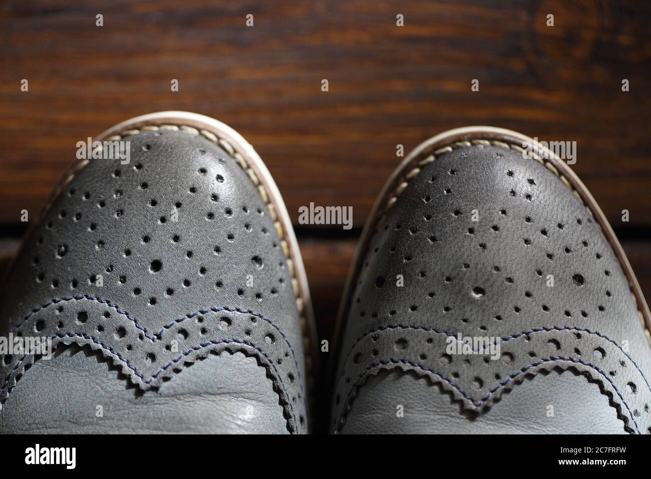 Graue oxford Schuhe auf Holzhintergrund. Draufsicht Stockfoto