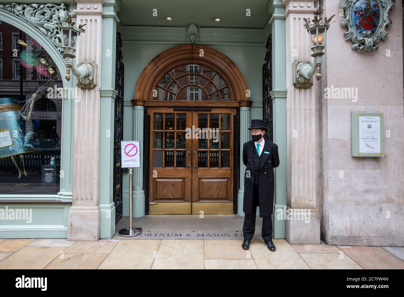 Der Portier trägt eine Gesichtsbedeckung vor dem Luxuskaufhaus Fortnum & Mason, nachdem es nach der Coronavirus-Sperre wieder eröffnet wurde, Piccadilly, London, Großbritannien Stockfoto Der Portier trägt eine Gesichtsbedeckung vor dem Luxuskaufhaus Fortnum & Mason, nachdem es nach der Coronavirus-Sperre wieder eröffnet wurde, Piccadilly, London, Großbritannien Stockfoto