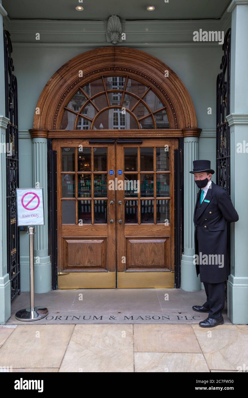 Der Portier trägt eine Gesichtsbedeckung vor dem Luxuskaufhaus Fortnum & Mason, nachdem es nach der Coronavirus-Sperre wieder eröffnet wurde, Piccadilly, London, Großbritannien Stockfoto Der Portier trägt eine Gesichtsbedeckung vor dem Luxuskaufhaus Fortnum & Mason, nachdem es nach der Coronavirus-Sperre wieder eröffnet wurde, Piccadilly, London, Großbritannien Stockfoto