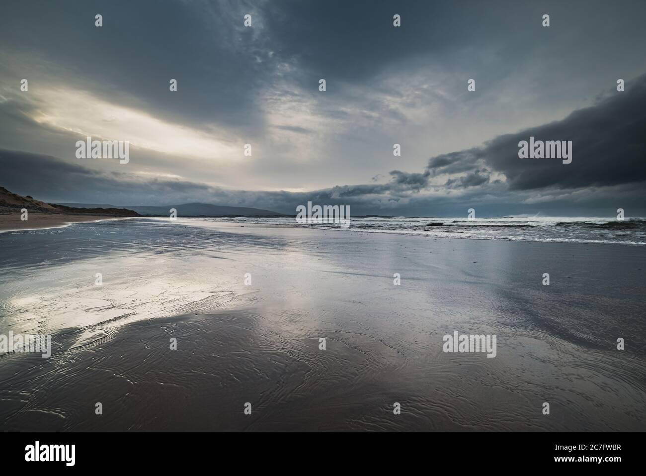 Strandhill Strand mit niedrigen Wolken auf rauem Meer. Wolkiger Sonnenuntergang am Strandhill mit tiefem Farbspektrum vermittelt tiefe Gedanken und melancholisches Konzept Stockfoto