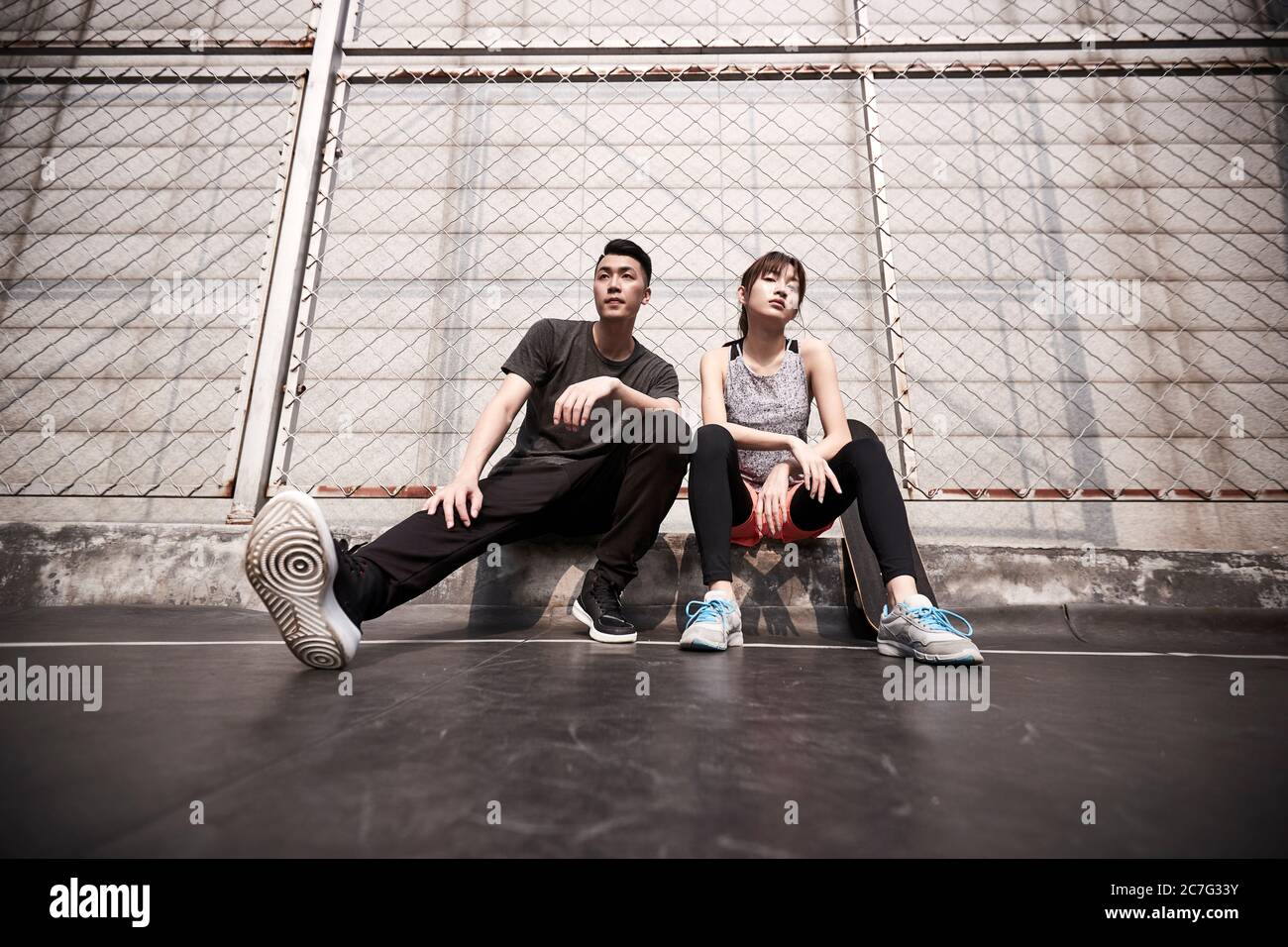 Junge asiatische Erwachsene Mann und Frau Ruhe nach der Übung mit kühlen Haltung Stockfoto