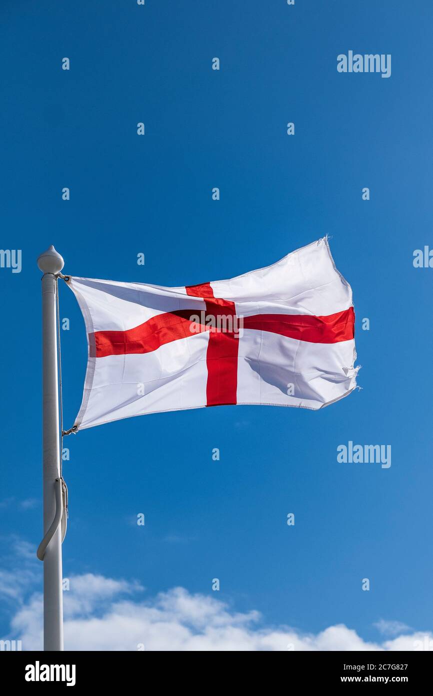 Eine Fahne des Kreuzes von St. George flattert im Wind gesehen gegen einen blauen Himmel. Stockfoto