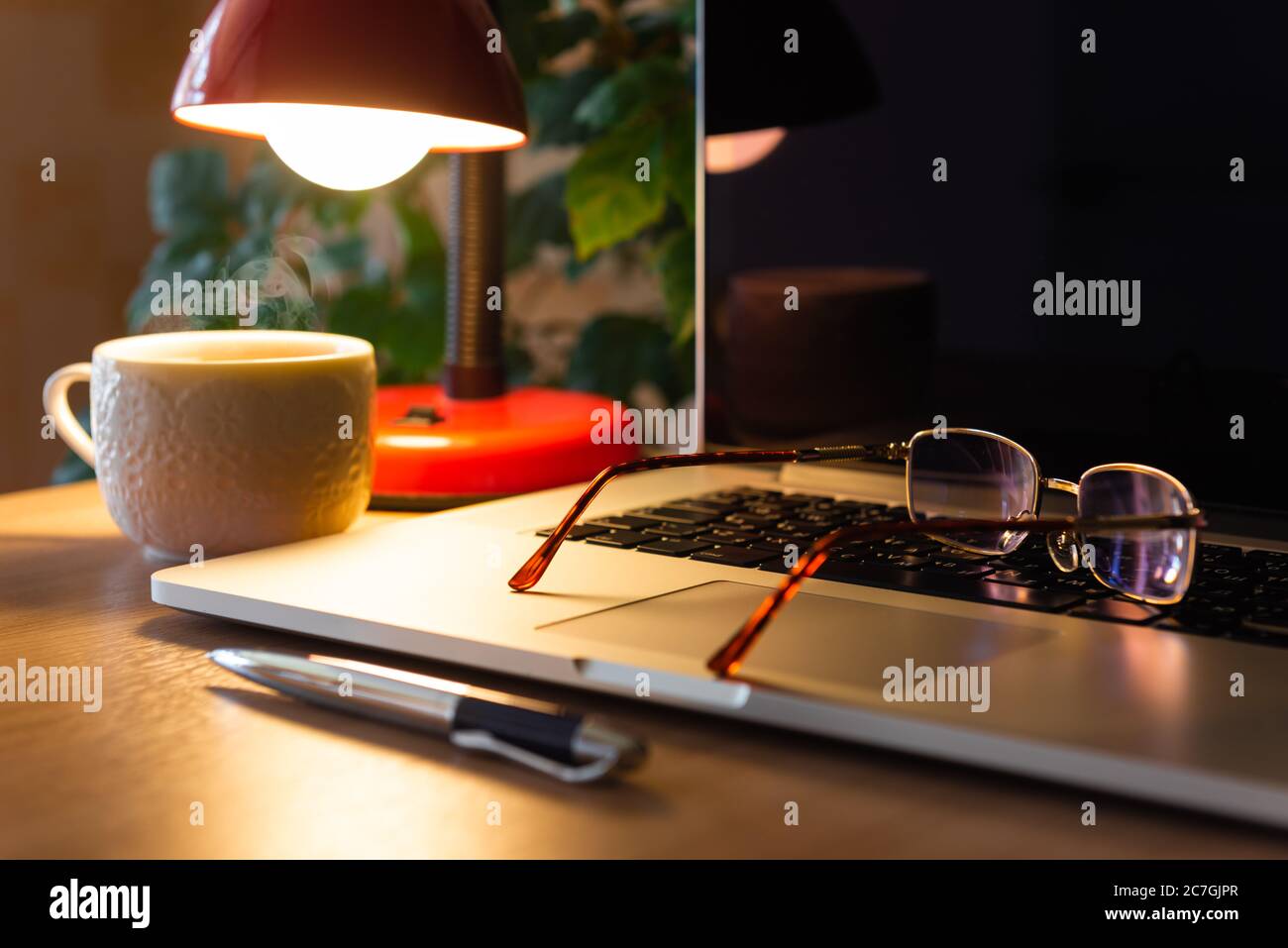 Brille auf Laptop, freiberuflicher Arbeitsplatz Stockfoto