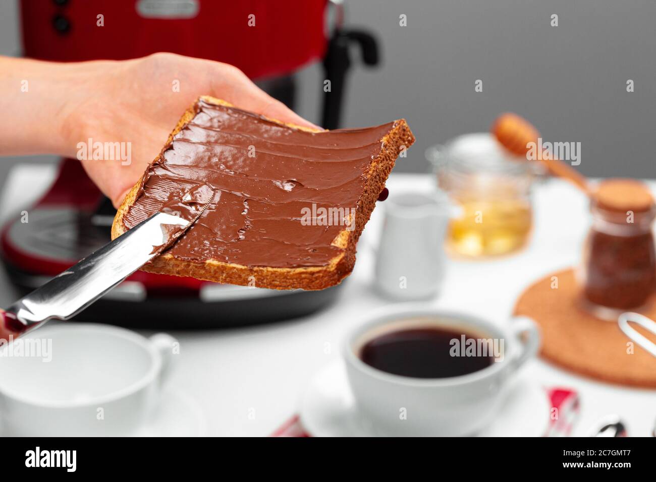 Weiblicher Handkochtoast mit Schokoladenpaste Stockfoto