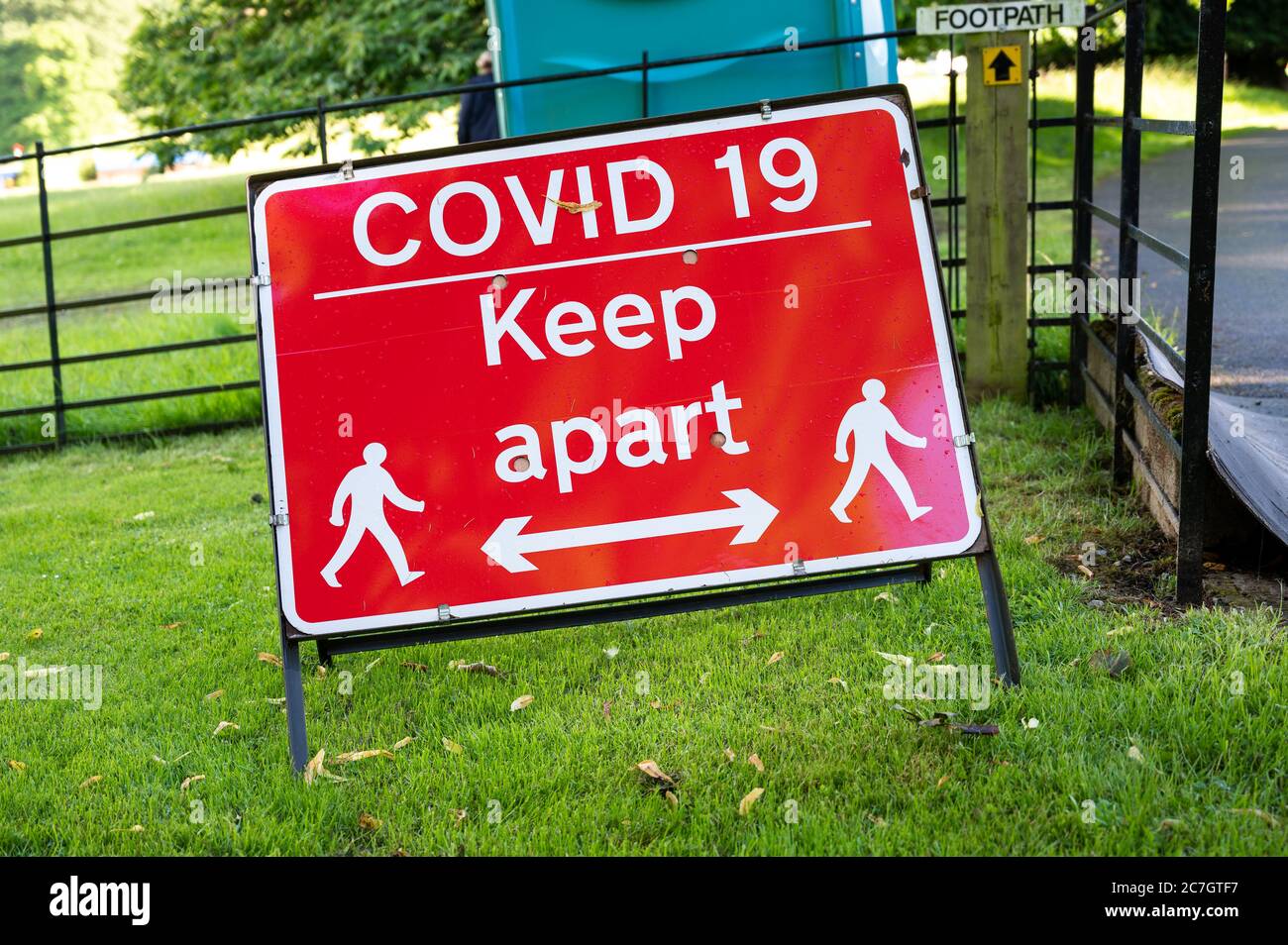 Ein Covid-19 soziales Distanzierungswarnschild bei einem Outdoor-Event. Stockfoto