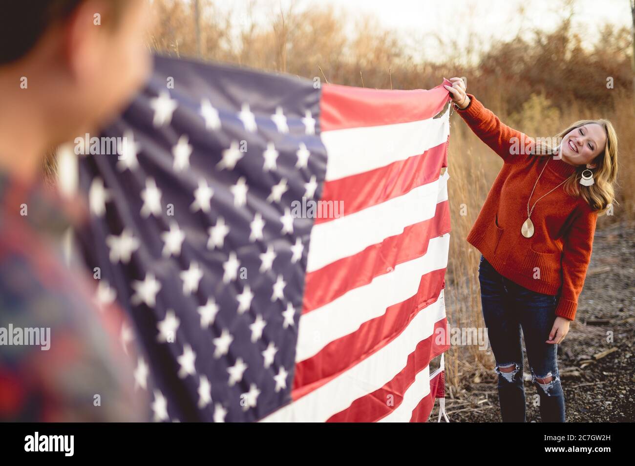 Paar hält die amerikanische Flagge weiß stehen in der Nähe der Eisenbahn Stockfoto