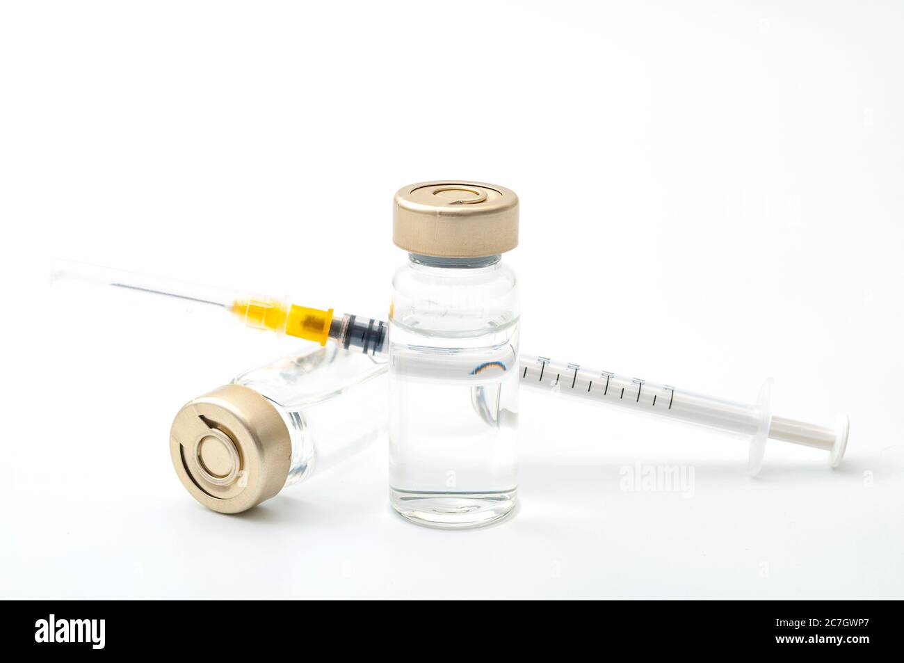 Impfstoffe, Botulinumtoxin und Insulinampullen – Konzeptthema mit Glasfläschchen mit klarer Flüssigkeit neben einer Spritze und einer auf W isolierten, hypodermischen Nadel Stockfoto