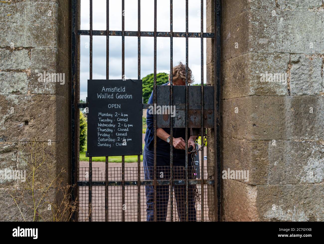 Freiwillige Entriegelung Eingangstor mit Öffnungszeiten, Amisfield Walled Garden, Haddington, East Lothian, Schottland, Großbritannien Stockfoto