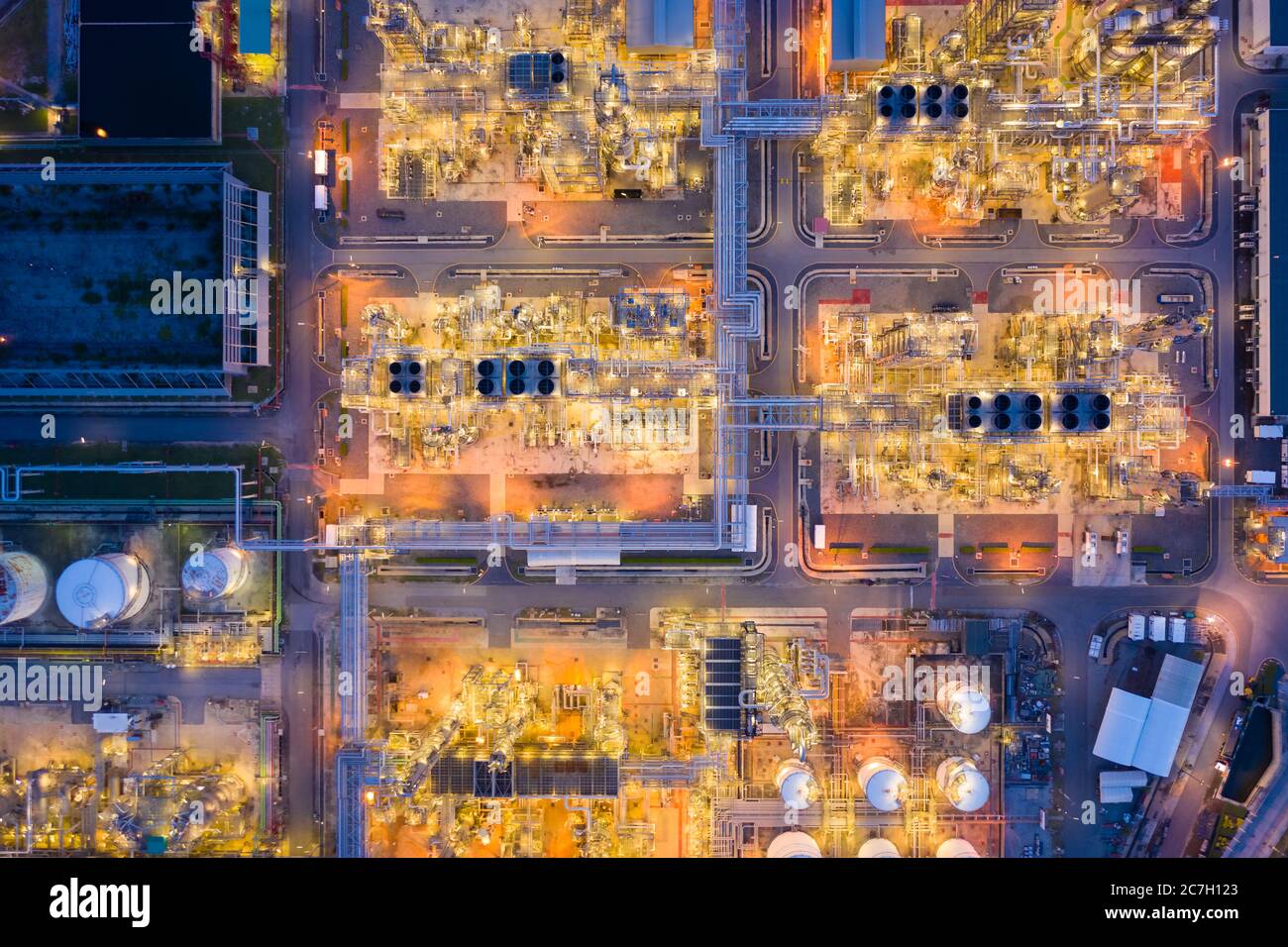 Luftaufnahme der Ölraffinerie-Anlage chemische Fabrik und Kraftwerk mit vielen Lagertanks und Rohrleitungen bei Sonnenuntergang. Stockfoto