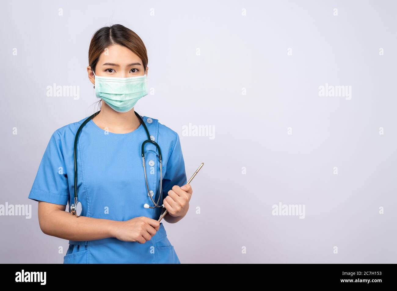 Porträt einer jungen asiatischen Krankenschwester mit einer chirurgischen Maske Stockfoto