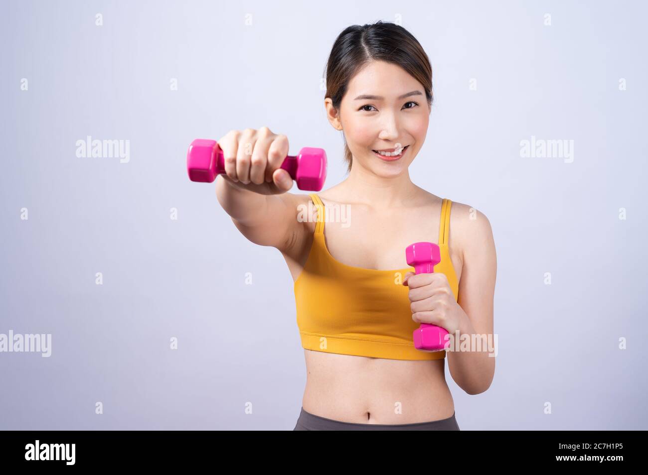 Asiatische sportliche Frau mit Hantel fit schlanken Körper isoliert auf weißem Hintergrund. Konzept der gesunden Lebensweise Stockfoto