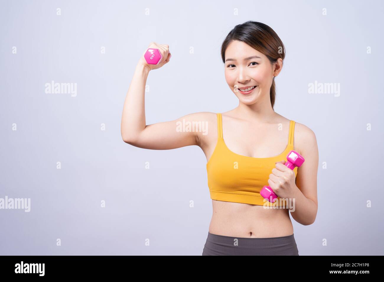 Asiatische sportliche Frau mit Hantel fit schlanken Körper isoliert auf weißem Hintergrund. Konzept der gesunden Lebensweise Stockfoto