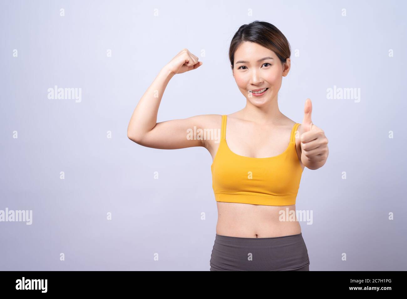 Portrait der asiatischen sportliche Frau geben Daumen nach oben isoliert auf weißem Hintergrund. Konzept der gesunden Lebensweise Stockfoto