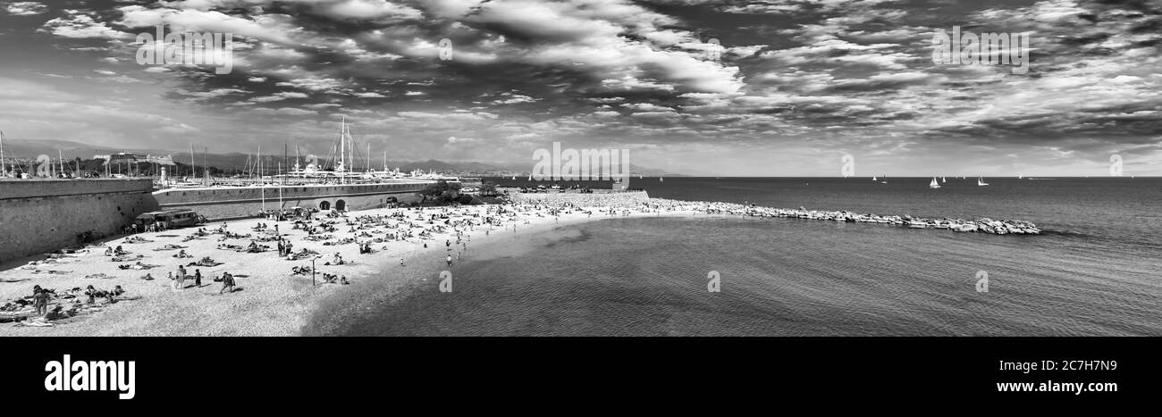 Schöner Strand von Cannes mit Touristen bei Sonnenuntergang, Frankreich. Stockfoto