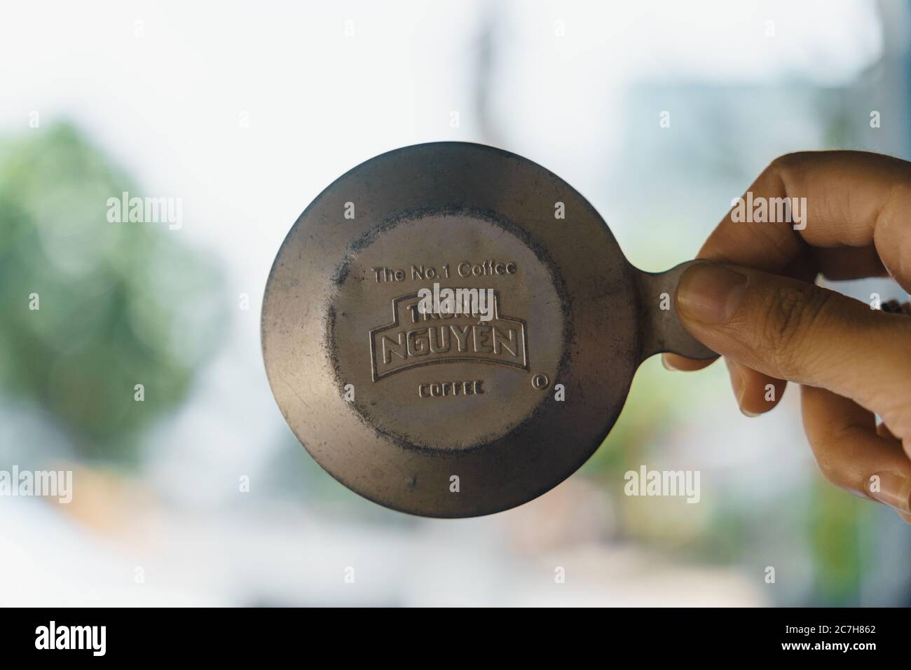 Pleiku Stadt, Vietnam - 12 Juli 2020: Nahaufnahme Hand hält Trung Nguyen Kaffee Deckel von vietnamesischen Phin Filter. Selektiver Fokus. Stockfoto