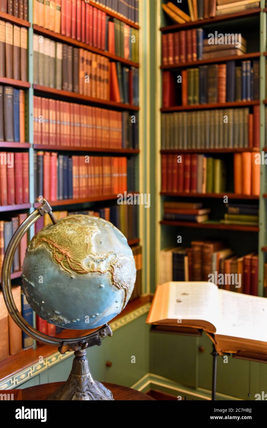 Eine Bürobibliothek mit einer Welt auf einem Schreibtisch Stockfoto
