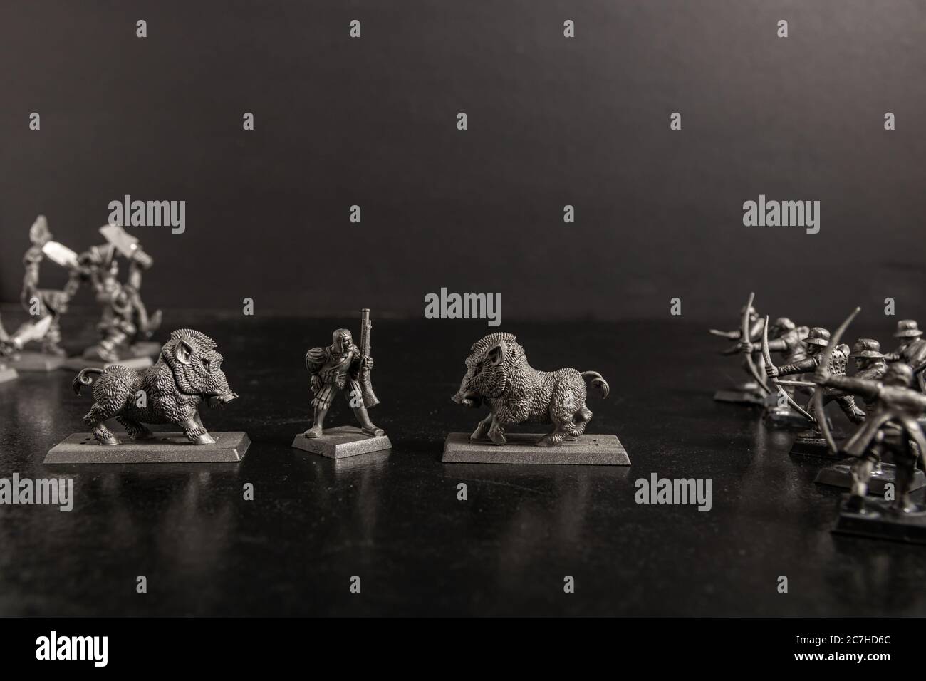 Graustufen selektive Fokus Aufnahme eines Jägers und Wildschweine Figuren Stockfoto