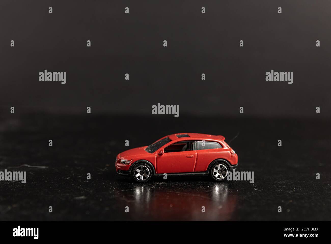 Selektive Fokusaufnahme eines roten Spielzeugautos auf einem Schwarze Oberfläche Stockfoto