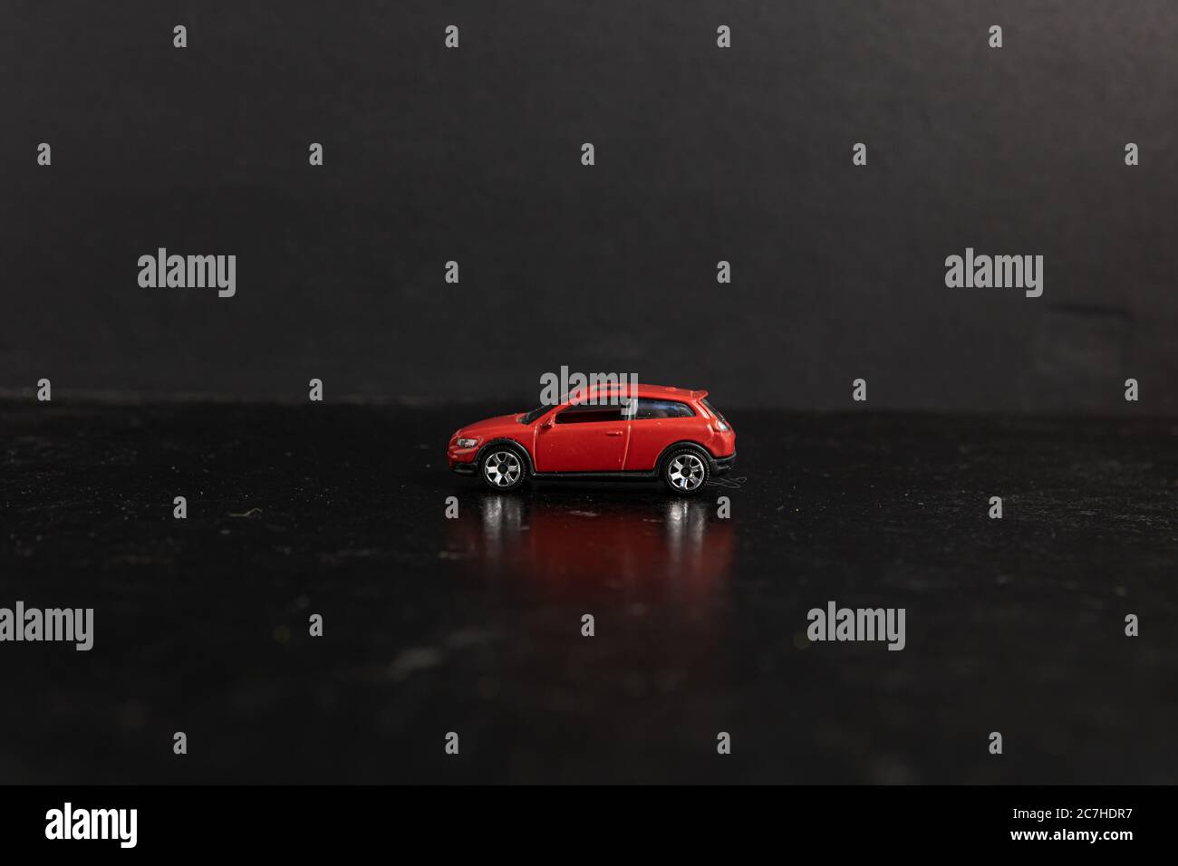 Selektive Fokusaufnahme eines roten Spielzeugautos auf einem Schwarze Oberfläche Stockfoto