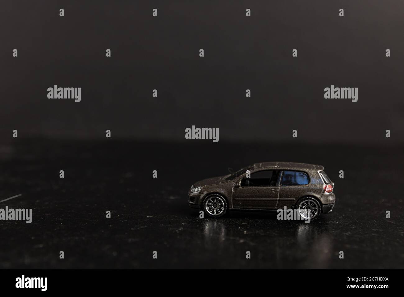 Selektive Fokusaufnahme eines braunen Spielzeugautos auf einem Schwarze Oberfläche Stockfoto