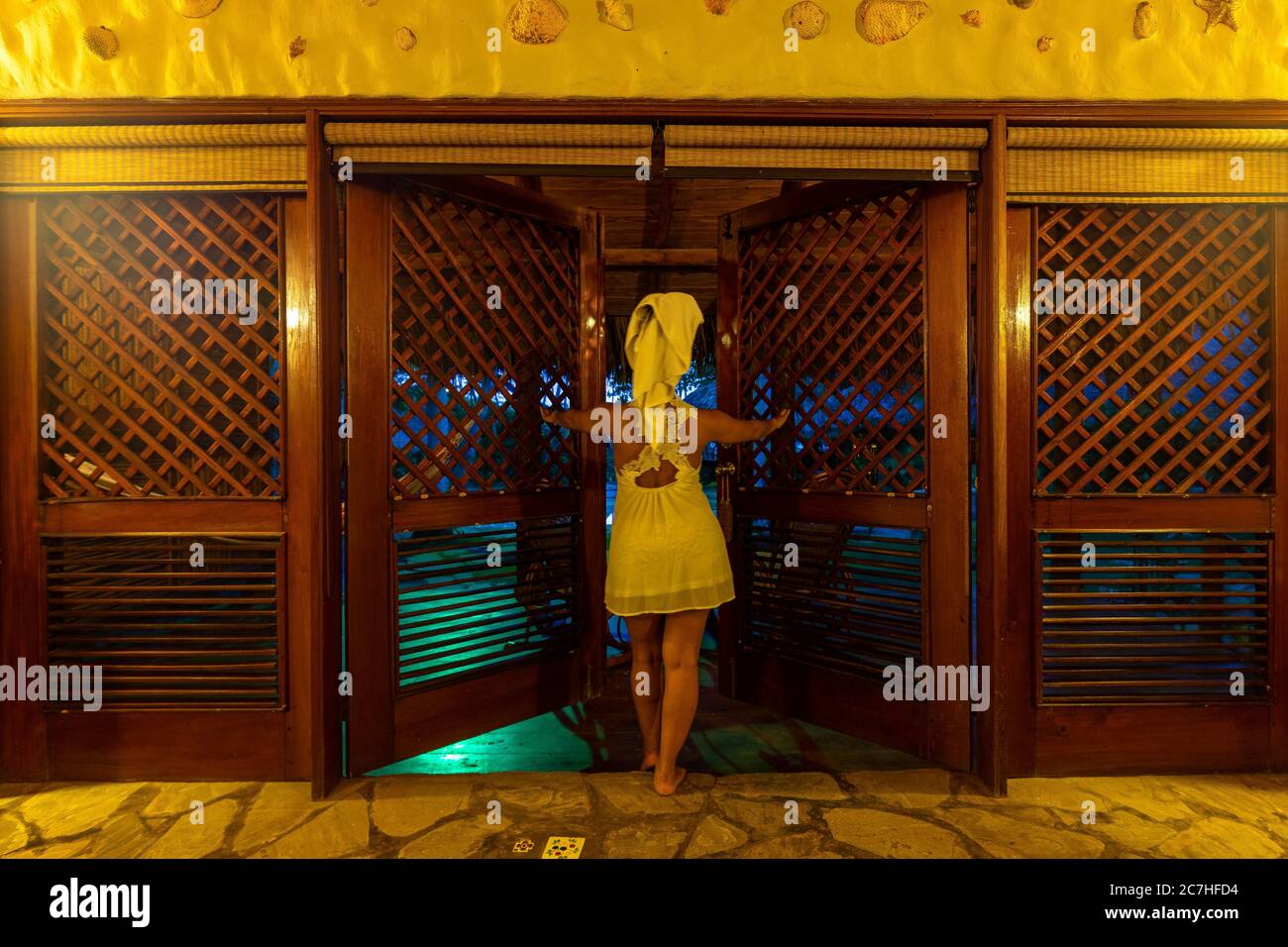 Amerika, Karibik, Großantillen, Dominikanische Republik, Cabarete, Frau öffnet die Tür ihres Bungalows im Natura Cabana Boutique Hotel & Spa Stockfoto