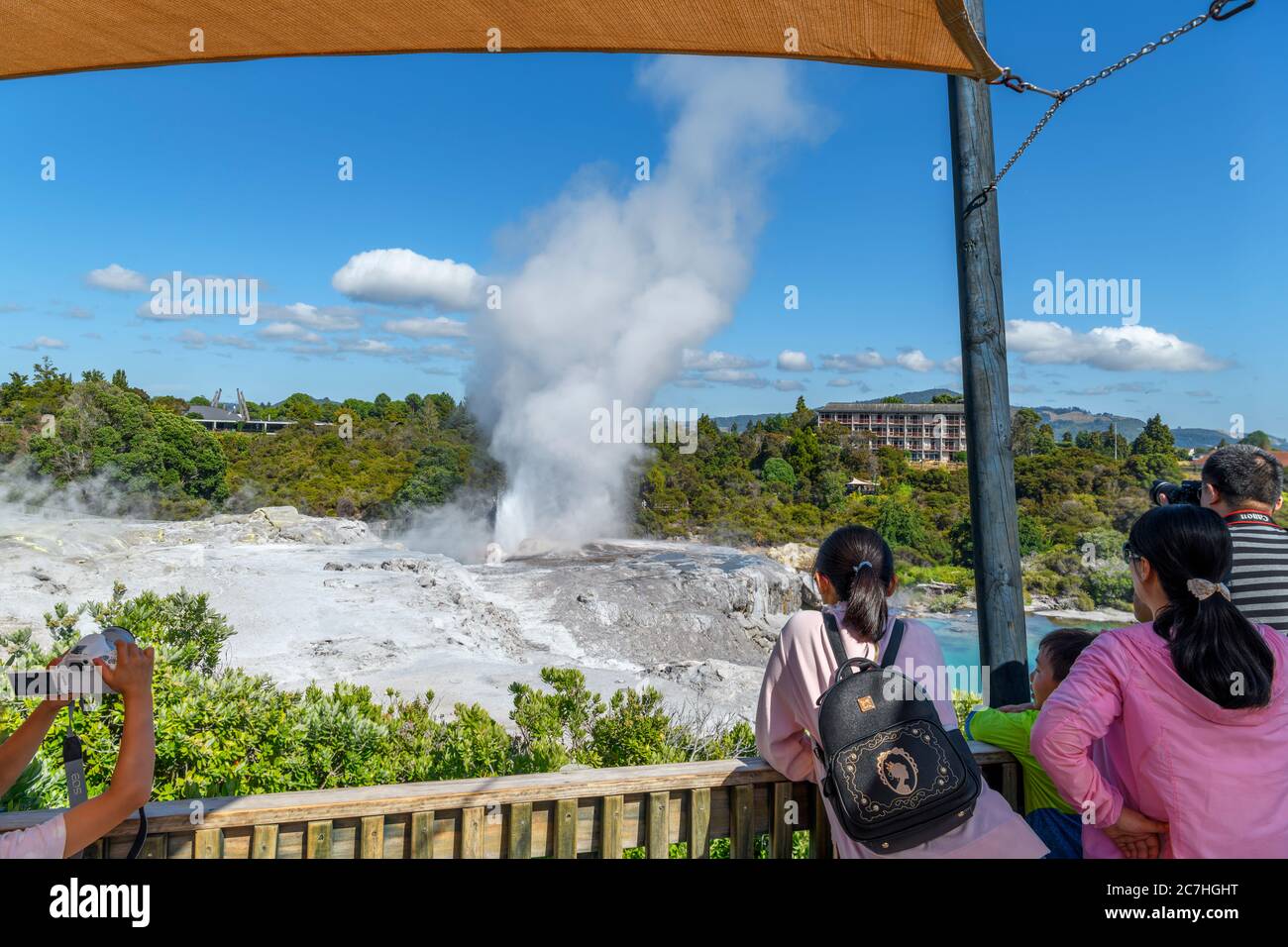 Besucher, die Pōhutu Geyser, Te Puia, Te Whakarewarewa Geothermal Valley, Rotorua, Neuseeland, besichtigen Stockfoto
