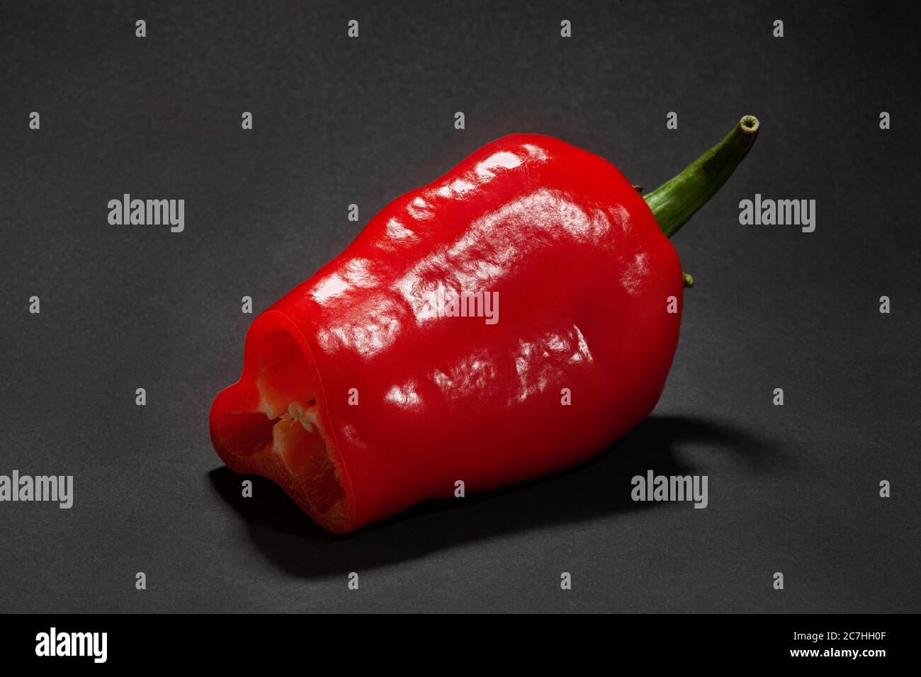 Geschnittene lange rote Paprika auf schwarzem Hintergrund Stockfoto