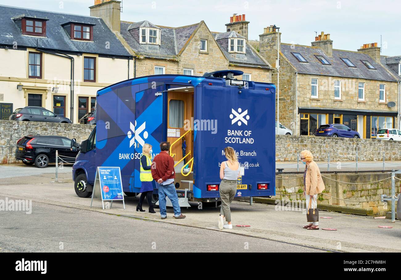 LOSSIEMOUTH MORAY COAST SCOTLAND COVID 19 EINSCHRÄNKUNGEN MENSCHEN MIT MASKEN SCHLANGE VOR BANK OF SCOTLAND MOBILE NIEDERLASSUNG Stockfoto