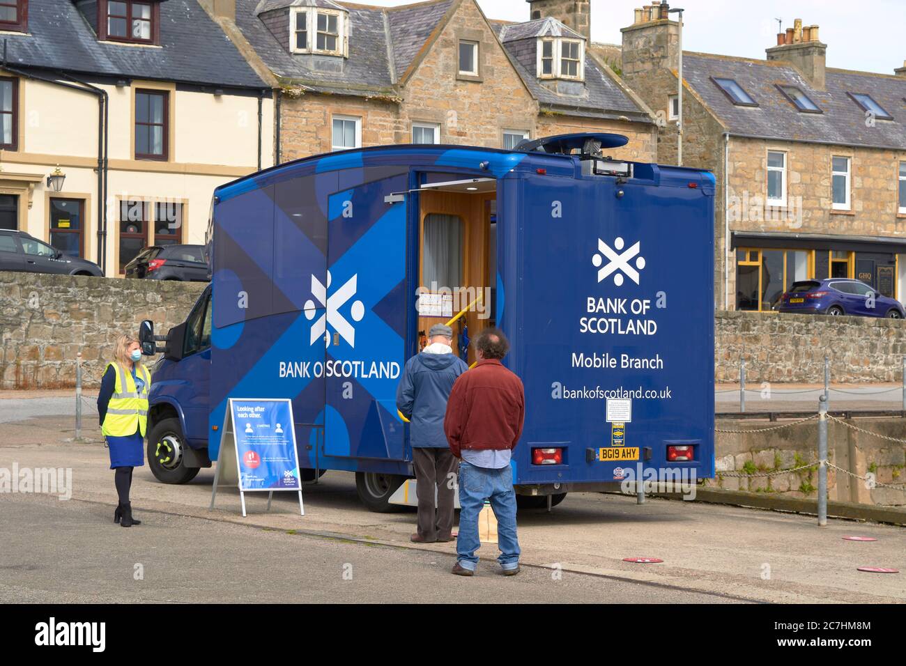 LOSSIEMOUTH MORAY KÜSTE SCHOTTLAND MENSCHEN SCHLANGE VOR BANK OF SCOTLAND MOBILE ZWEIG Stockfoto