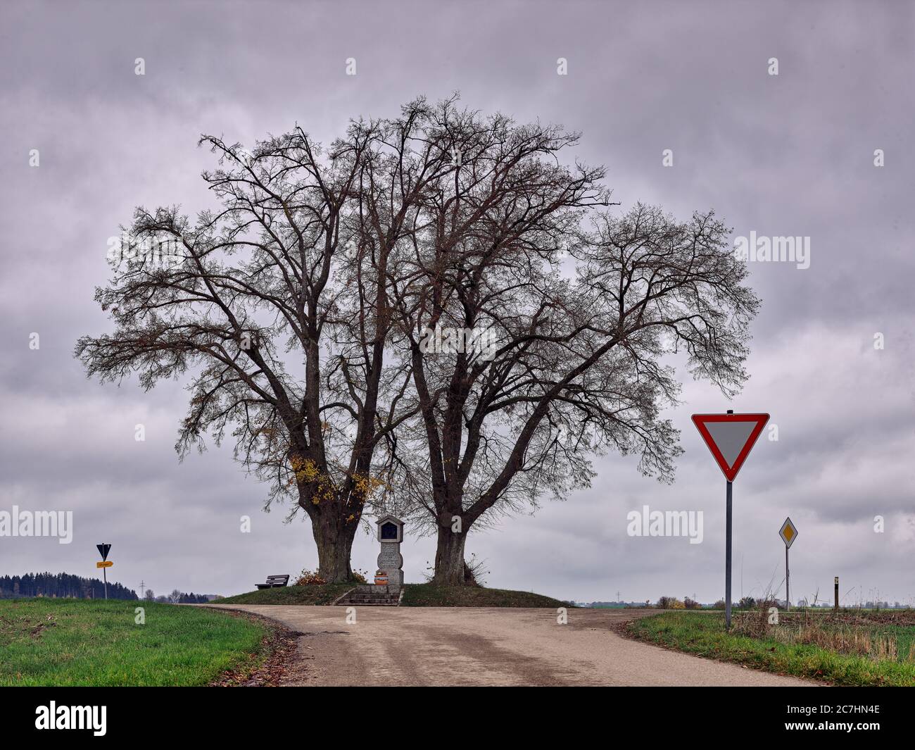 Baum, Baumgruppe, Kreuz, Gedenkstein, Straße, Verkehrszeichen, Herbst, Herbststimmung, Wolken Stockfoto
