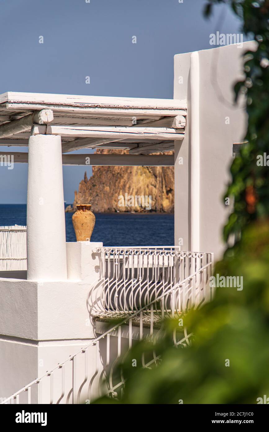 Sizilien - sonnige Eindrücke der Äolischen Inseln, auch als Äolische Inseln oder Isole Eolie bekannt: Lipari, Stromboli, Salina, Vulcano, Panarea, Filicudi und Alicudi. Blick auf Lisca Bianca über eine Dachterrasse mit Terrakotta-Amphore, Panarea. Stockfoto