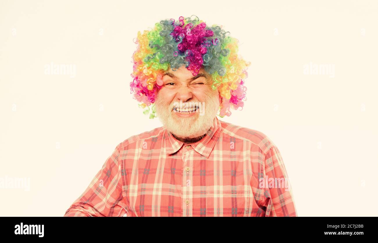 Lustiger Lebensstil. Spaß und Unterhaltung. Comic Happy Grandfather Konzept. Zirkus-Show. Älterer Clown. Mann Senior bärtige fröhliche Person trägt bunte Regenbogenperücke. Opa immer Spaß. Viel Spaß. Stockfoto
