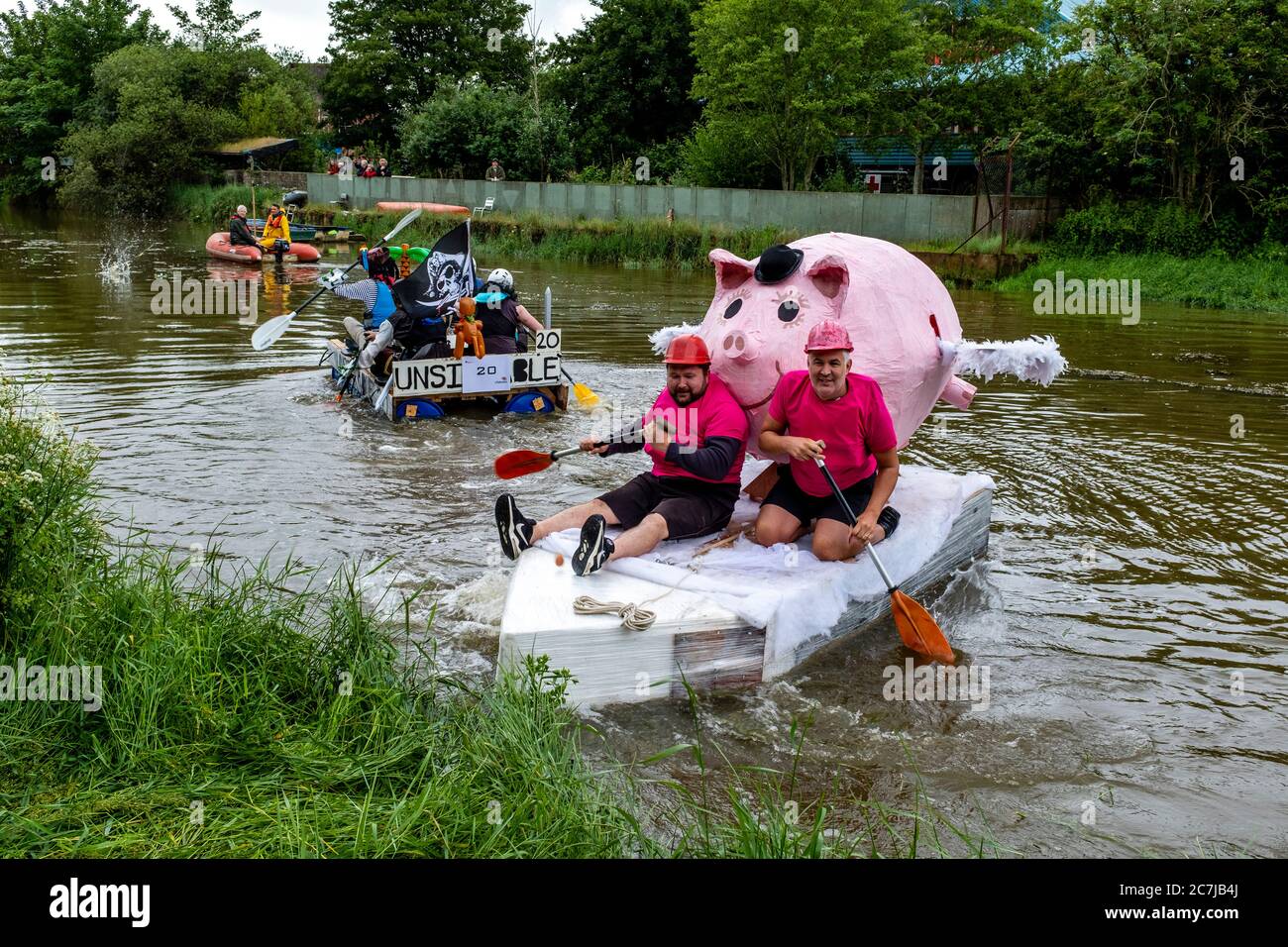 Die Einheimischen nehmen am jährlichen ‘Ouseday’ Raft Race Teil, dem Paddeln auf selbst hergestellten Rafts in Aid of Charity von Lewes nach Newhaven, River Ouse, Lewes, Großbritannien Stockfoto