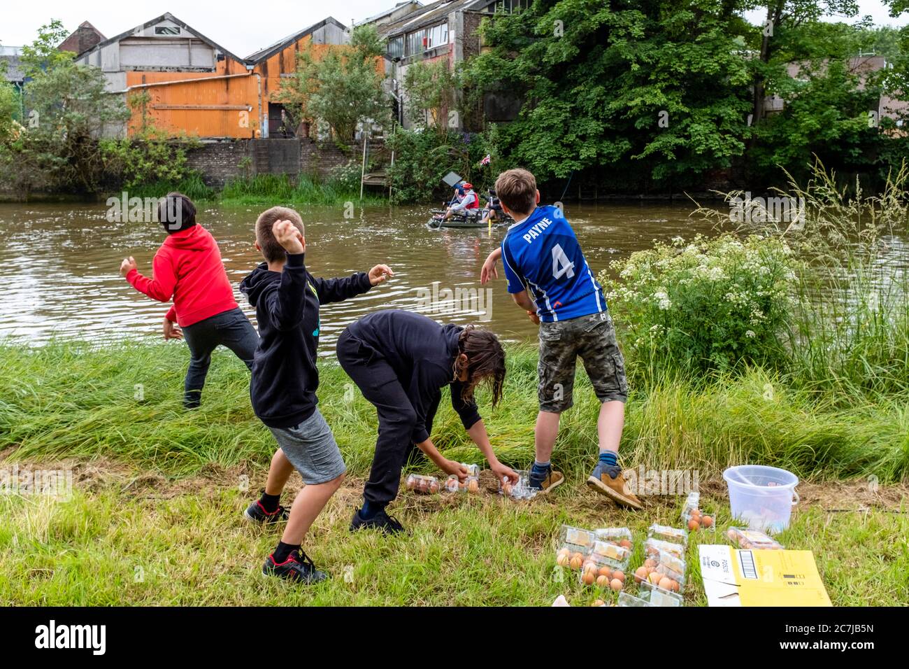 lokale-kinder-werfen-eier-auf-den-rafts-die-am-jahrlichen-ouseday-lewes-to-newhaven-floss-race-auf-dem-river-ouse-lewes-sussex-grossbritannien-teilnehmen-2c7jb5n.jpg