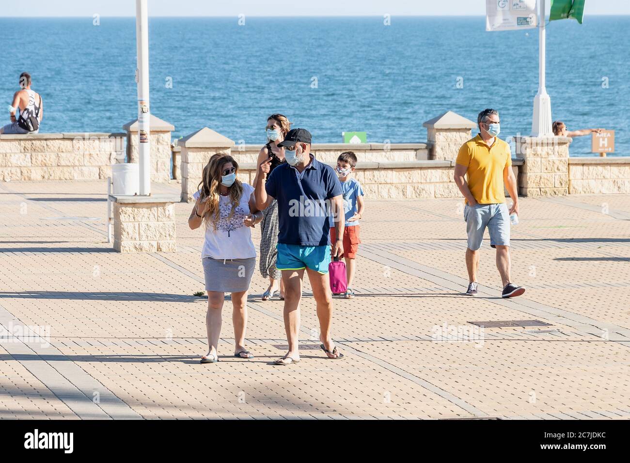 Huelva, Spanien - 3. Juni 2020: Menschen, die an der Islantilla Promenade entlang gehen, tragen Schutzmaske wegen Covid-19. Stockfoto