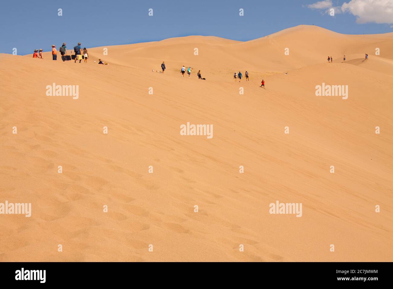 Gruppen von Wanderern wandern auf riesigen Wüstensanddünen im Great Sand Dunes National Park in Alamosa, Colorado, USA Stockfoto