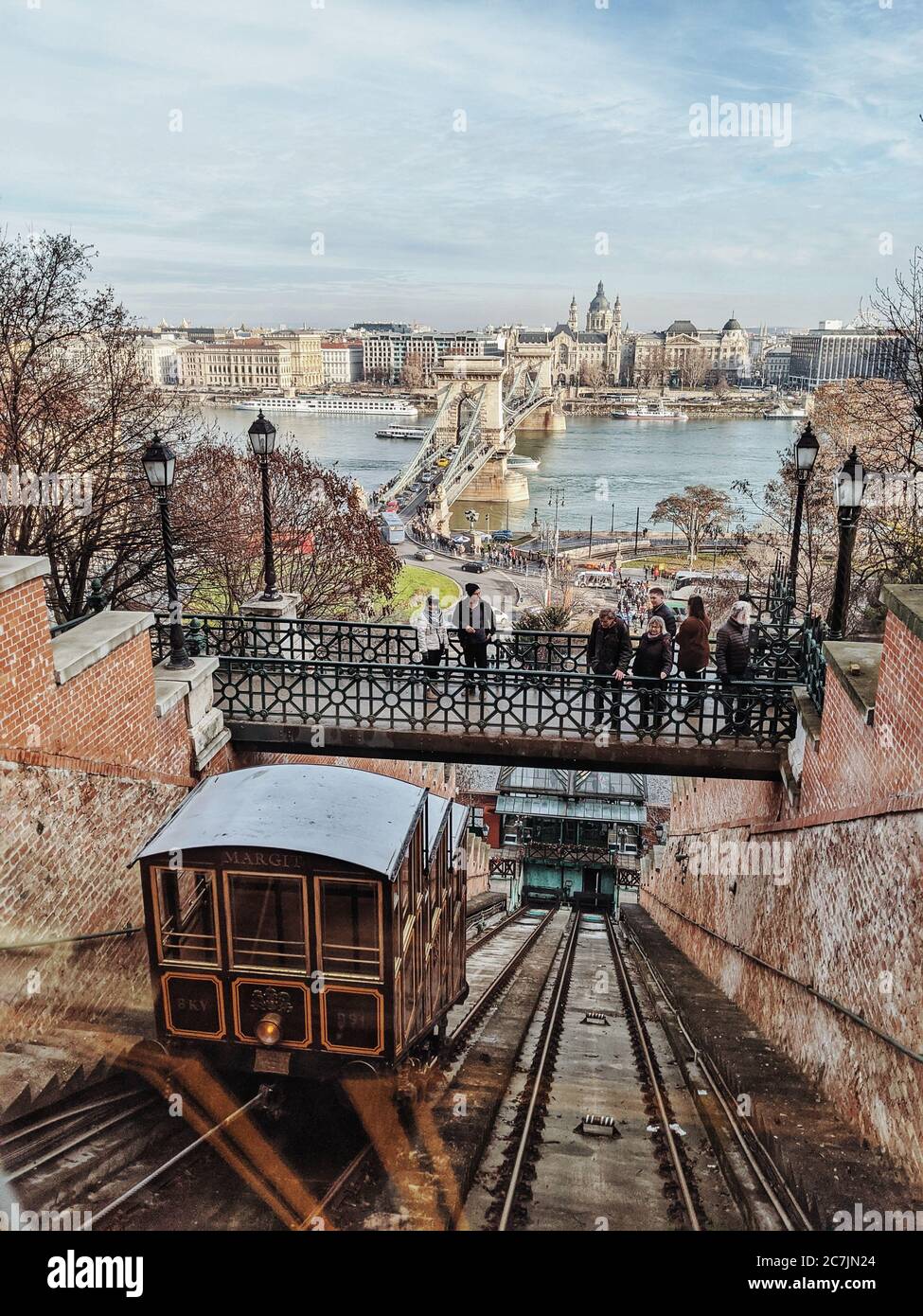 Die Menschen stehen auf einer Brücke und beobachten die Kabinen der Budavári Sikló-Standseilbahn, die sie zum Budapester Burgviertel führt Stockfoto