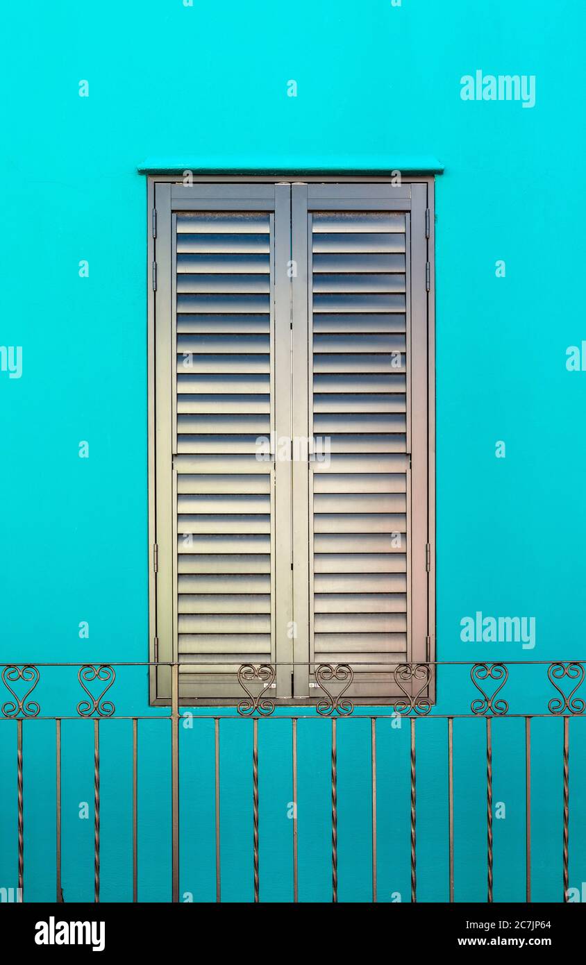 Geschlossenes Eisengeisenfenster und schmiedeeiserne Dekorationen mit türkisfarbener Fassade, Bo Kaap malay Viertel, Kapstadt, Südafrika. Stockfoto