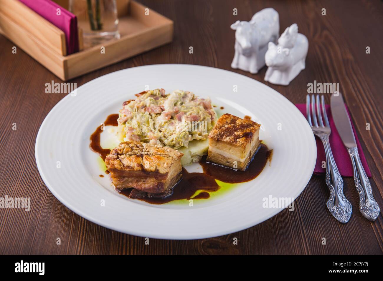 Schweinefleisch Medaillons mit Kartoffelpüree und Salat auf einem weißen Teller serviert, Restaurant-Menü Stockfoto